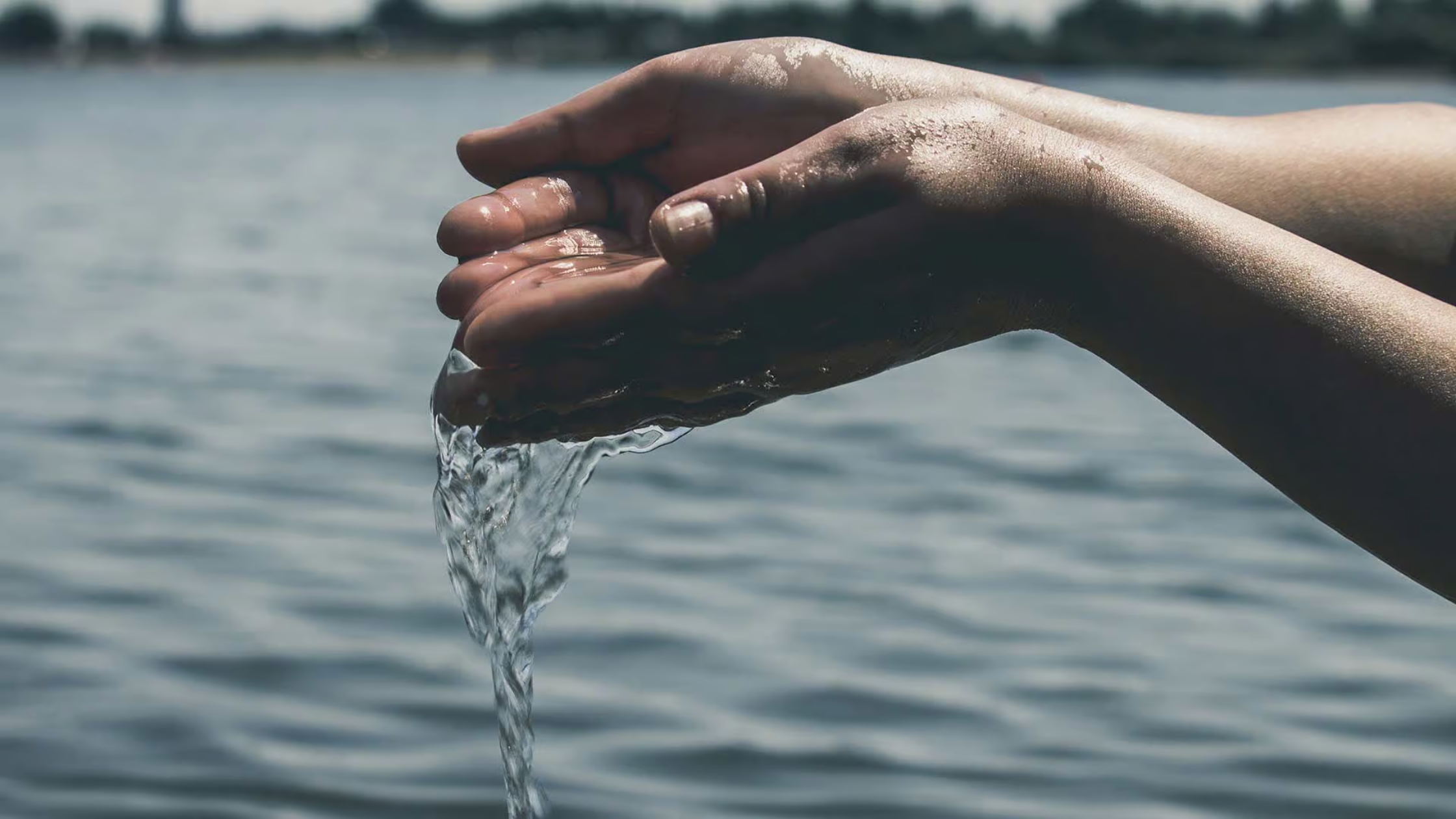 Un par de manos recogiendo agua fresca