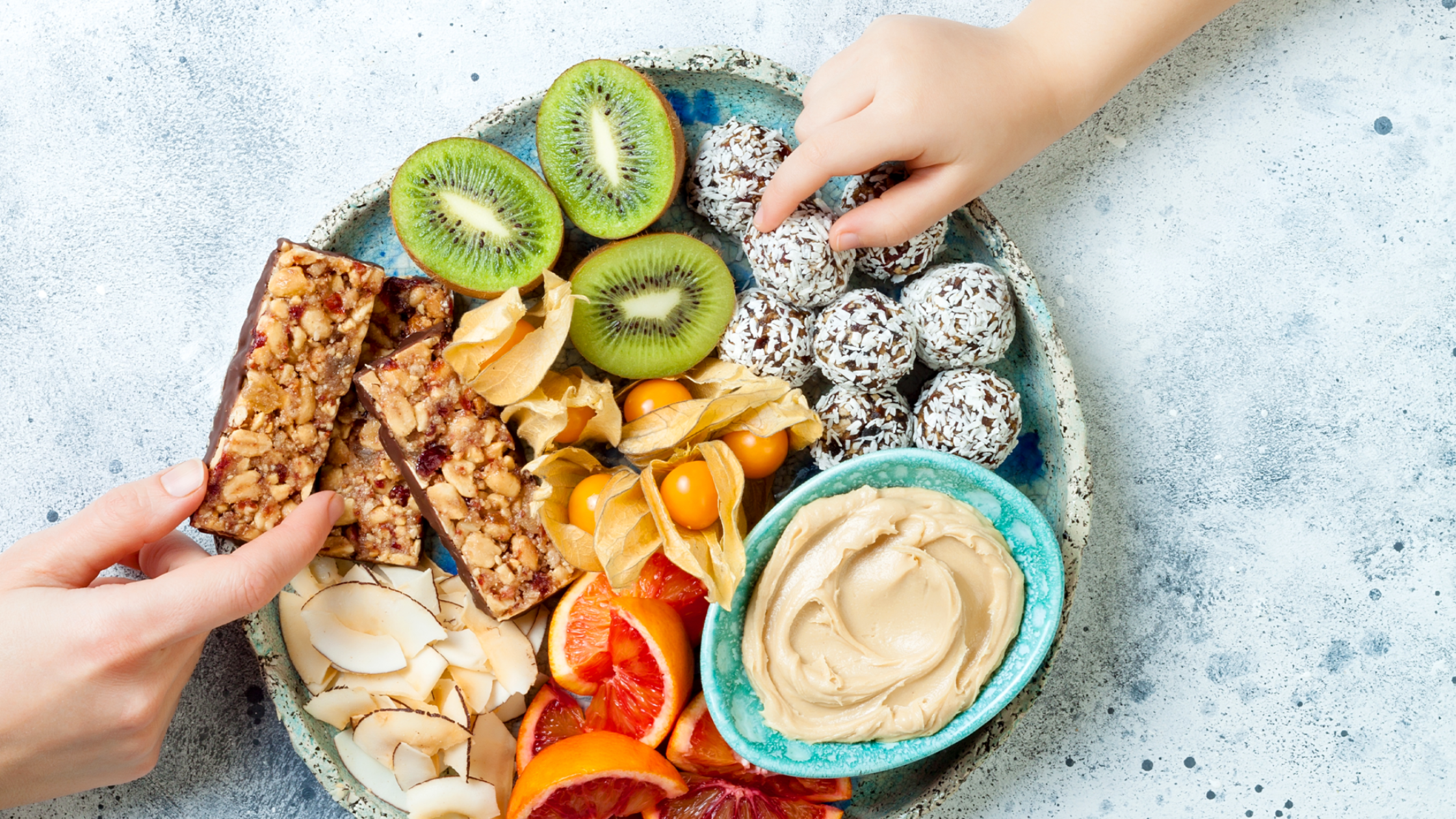 Plato con frutas, barritas y bolitas energéticas, fruta y mantequilla de maní