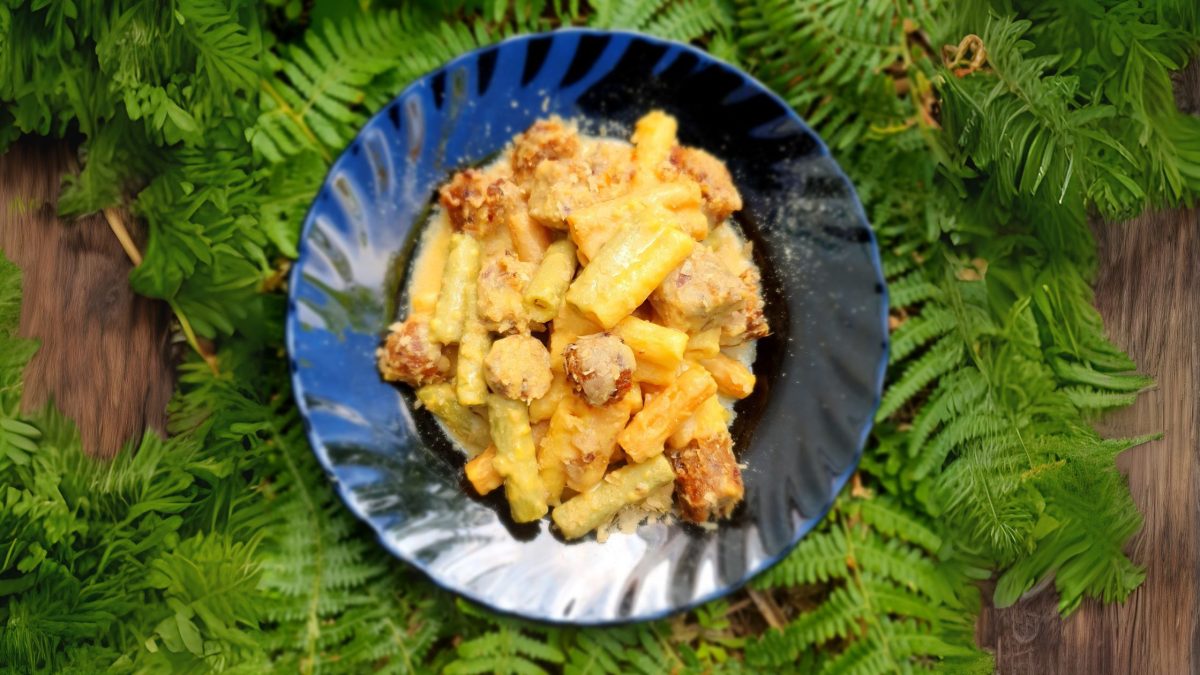 Foto de un plato con una porción de macarrones con queso y salchicha vegana.