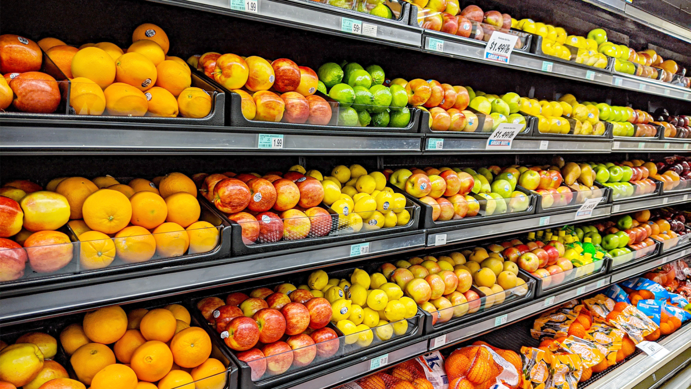 Estantería de supermercado llena de frutas de colores